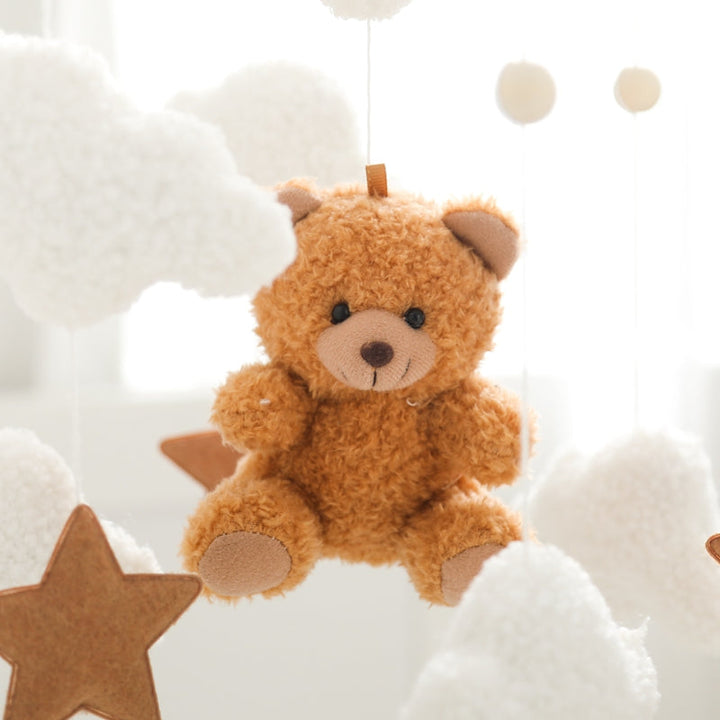 Close-up of the brown plush bear surrounded by white clouds and a brown star