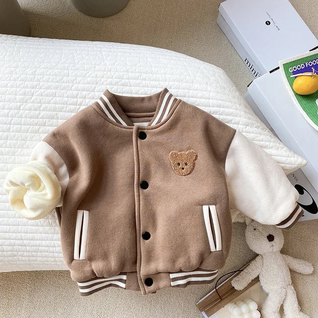 Brown baseball jacket laid flat with two front pockets and contrasting cream sleeves