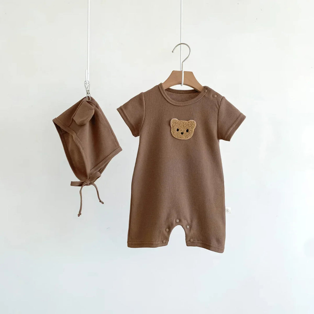 Brown bear-detail baby romper and matching hat hanging side by side