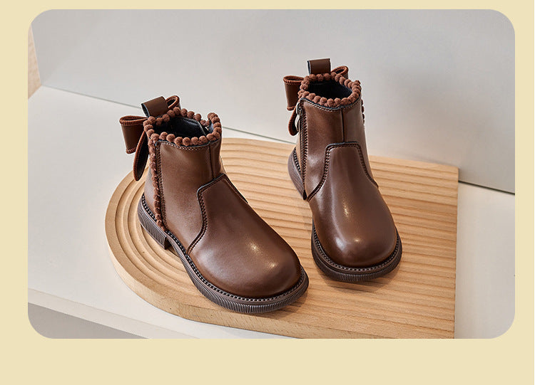 Pair of brown ankle boots with rounded toes, back bows, and decorative trim