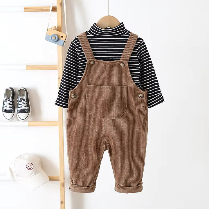 Brown corduroy overalls styled over a black-and-white striped long-sleeve top