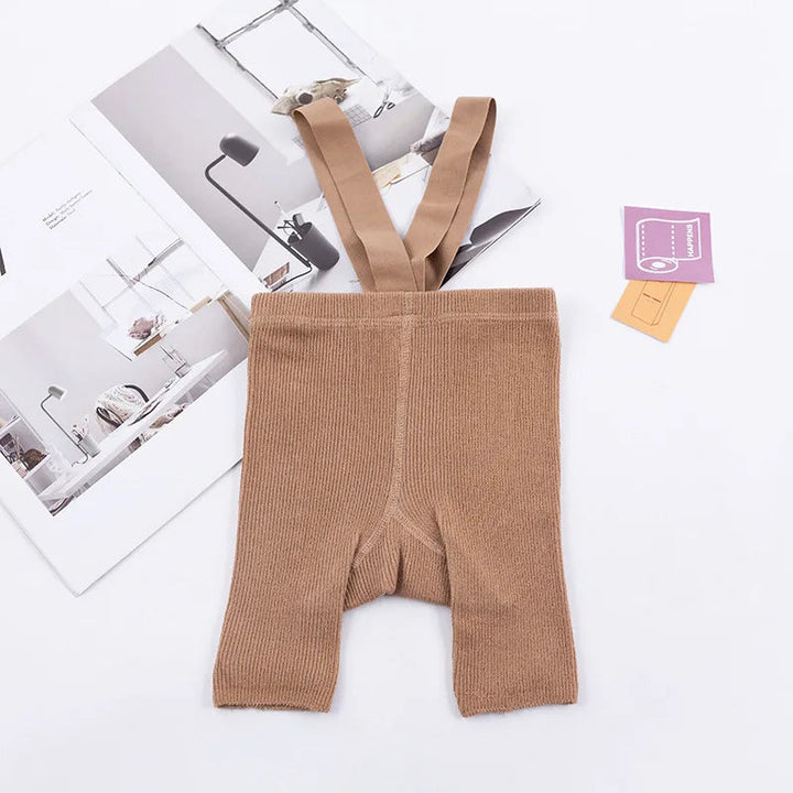 Brown ribbed suspender shorts laid flat with matching shoulder straps.