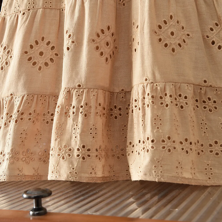 Brown dress skirt detail with gathered tiers and floral eyelet embroidery