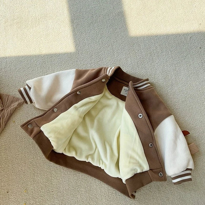Open brown baseball jacket showing a pale lining, front snaps and cream sleeves
