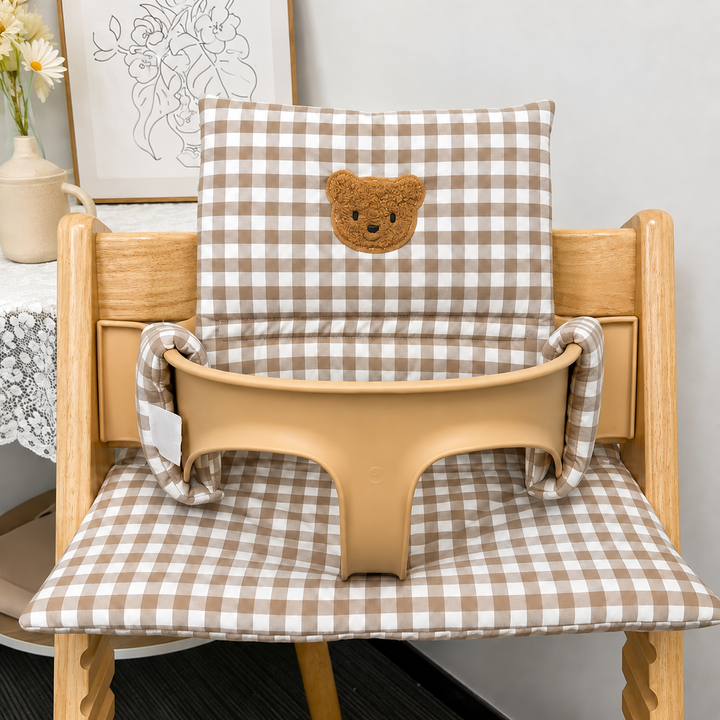 Brown gingham high chair cushion with a bear face patch on the backrest