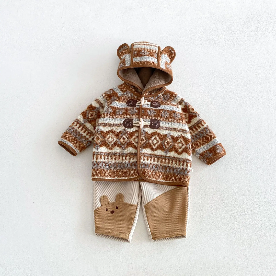 Brown patterned hooded jacket paired with cream and tan animal-detail pants