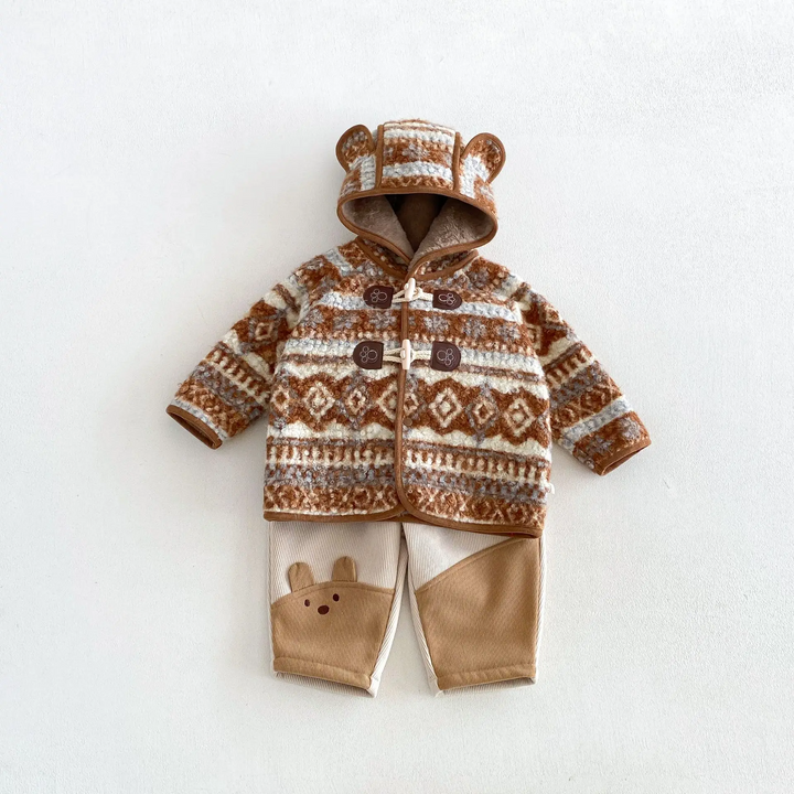 Brown patterned hooded jacket paired with cream and tan animal-detail pants