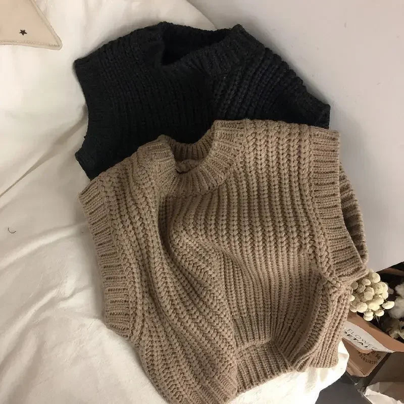 Brown cotton sweater vest laid over a black vest, showing the ribbed hem