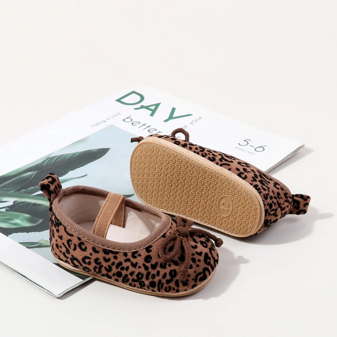 Brown leopard-print baby shoes showing the elastic instep strap and textured TPR sole