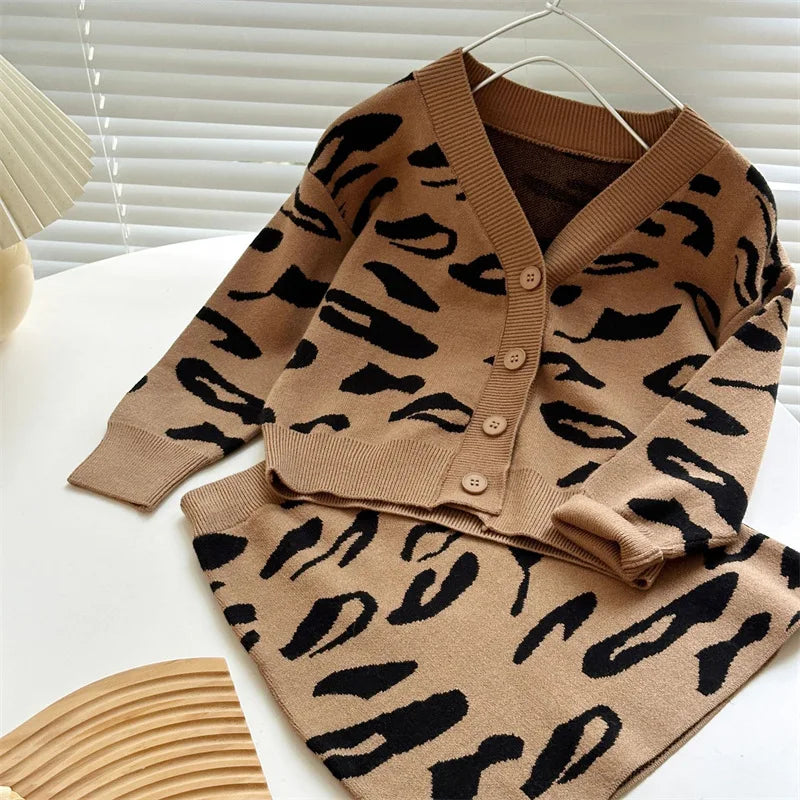 Brown leopard-pattern knit cardigan hanging above a matching skirt.