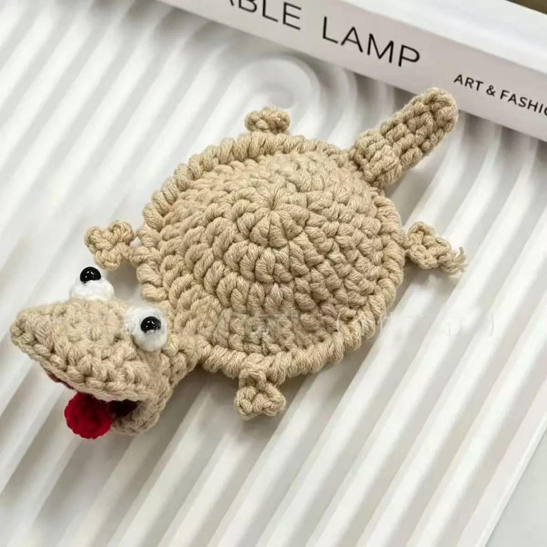 Brown lizard coaster with a round crocheted center, long tail, and red tongue