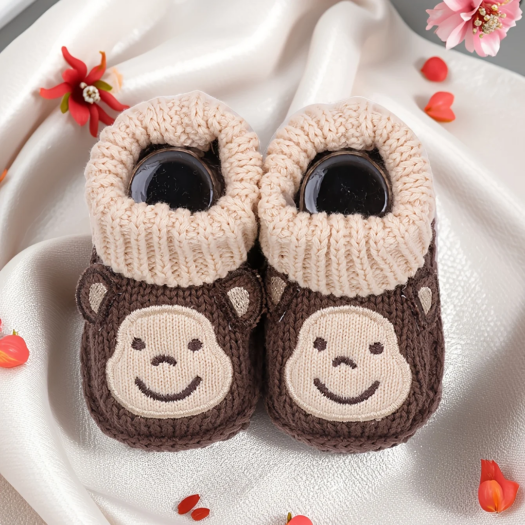 Brown monkey baby booties with beige ribbed cuffs and smiling faces