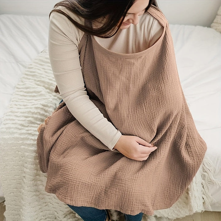 Seated mother looking down through the neckline of a brown nursing cover