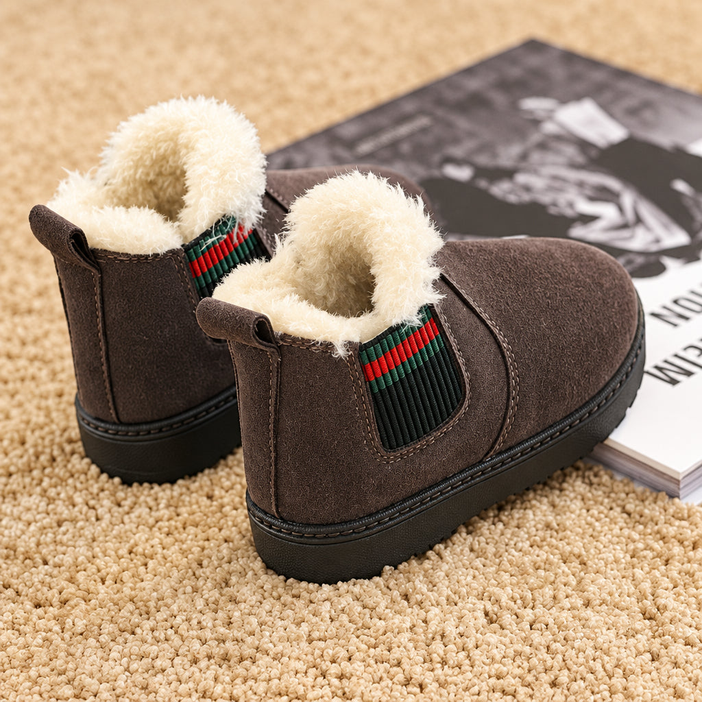 Brown suede winter boots with plush collars and elastic side panels on a beige carpet.