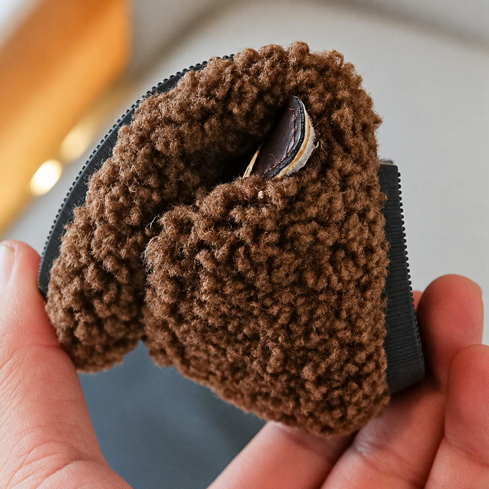 Brown plush shoe bent by hand to show its flexible sole