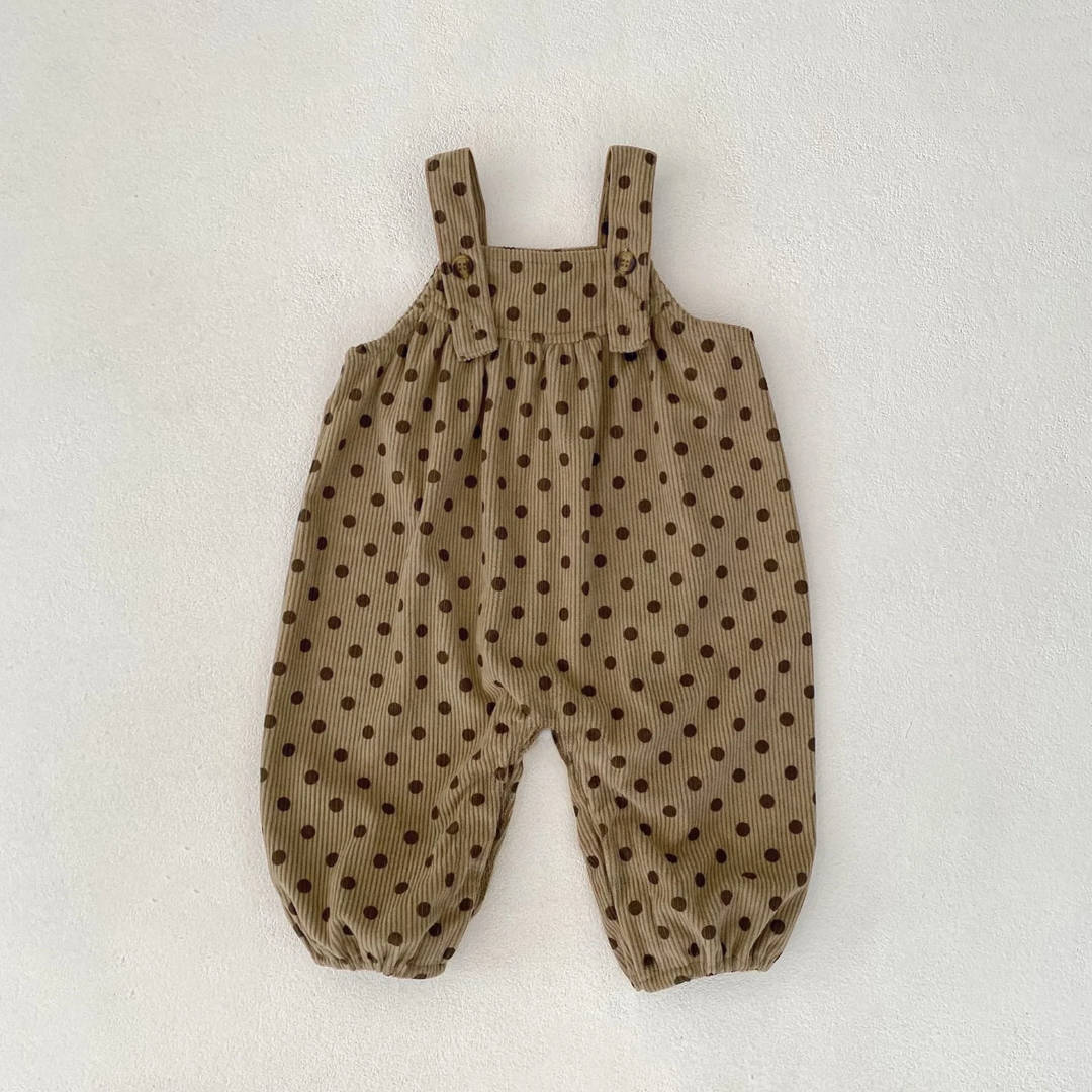 Brown polka-dot baby jumpsuit with buttoned straps and elastic leg openings, laid flat.