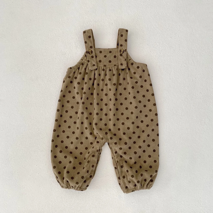 Brown polka-dot baby jumpsuit with buttoned straps and elastic leg openings, laid flat.
