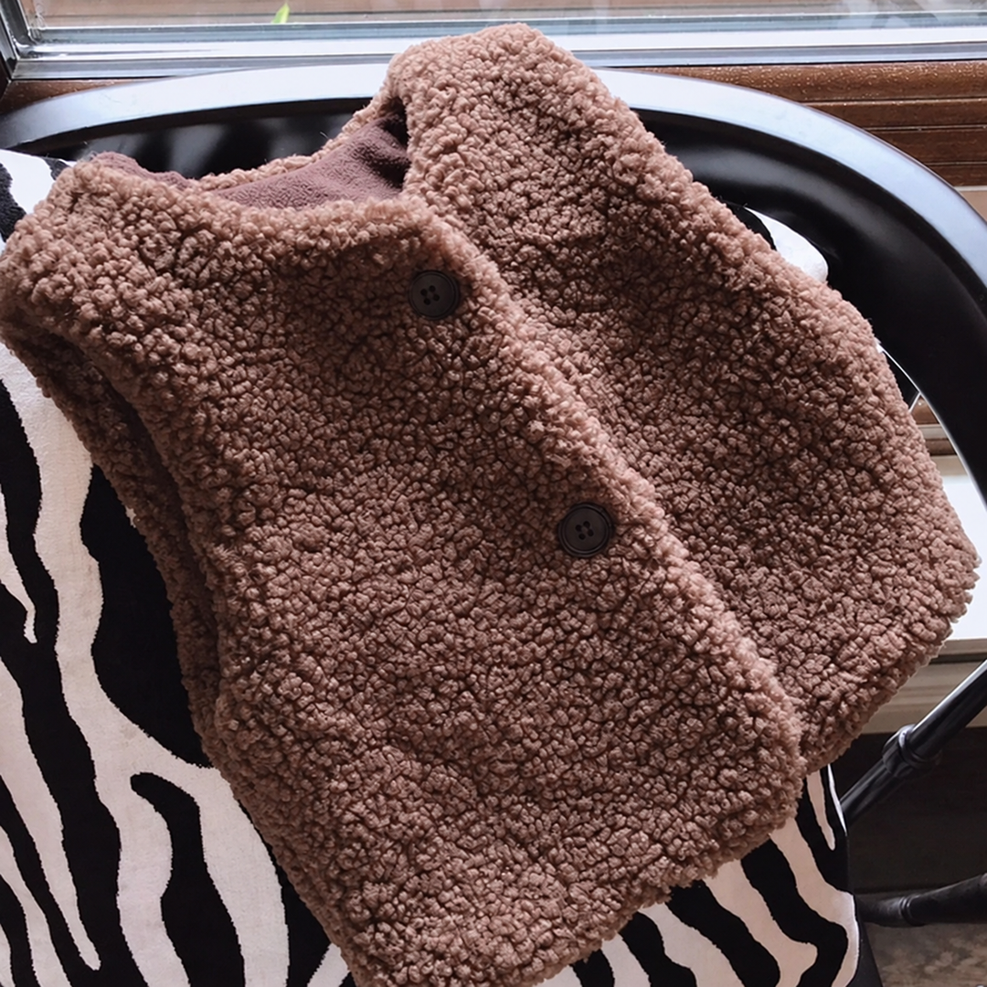 Front view of a brown plush vest with a rounded neckline and two-button closure