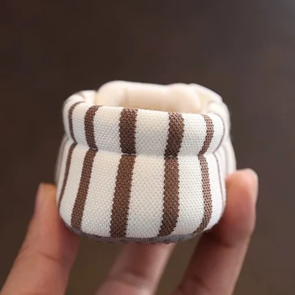 Back view of a brown striped baby shoe with a soft fabric heel