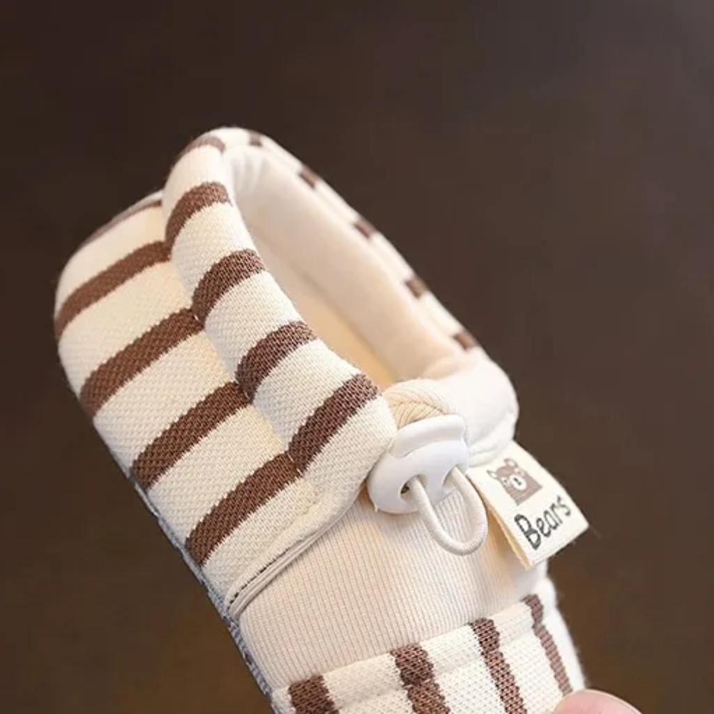 Side view of a brown striped baby shoe showing the elastic band closure