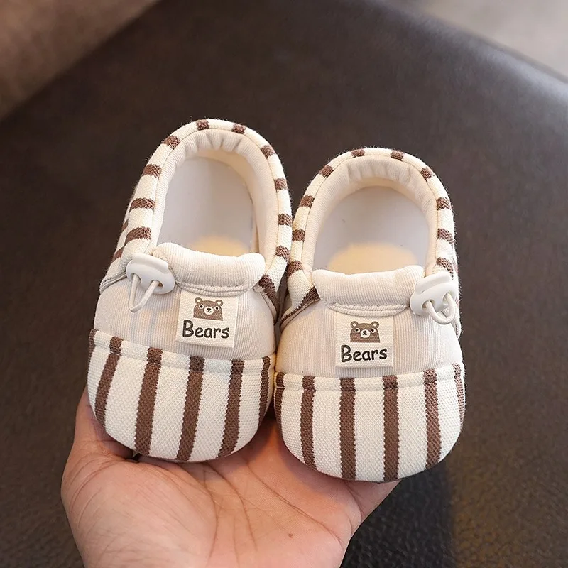 Pair of brown striped baby shoes with elastic closures and bear details
