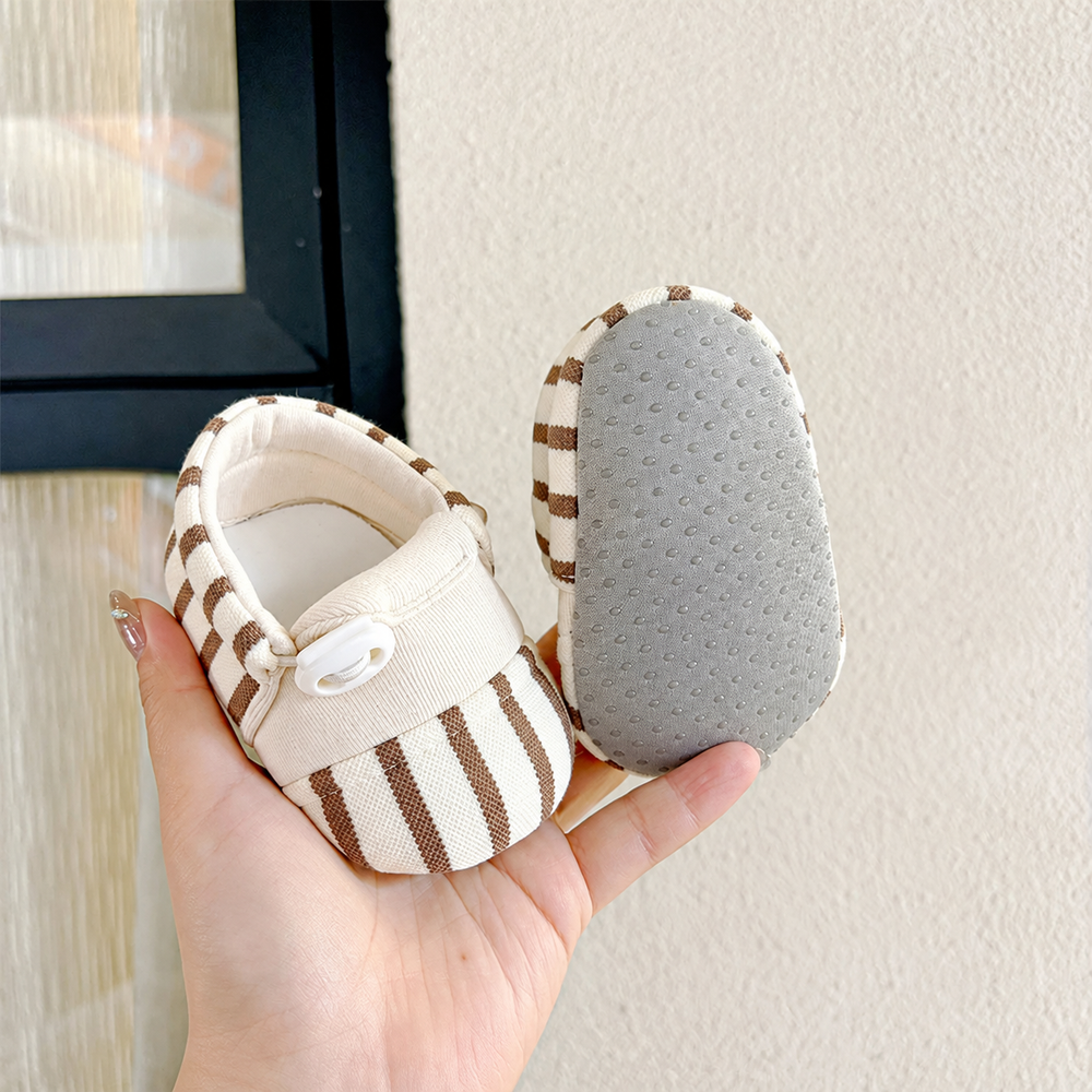 Brown-and-cream striped baby shoes showing the upper and gray dotted sole