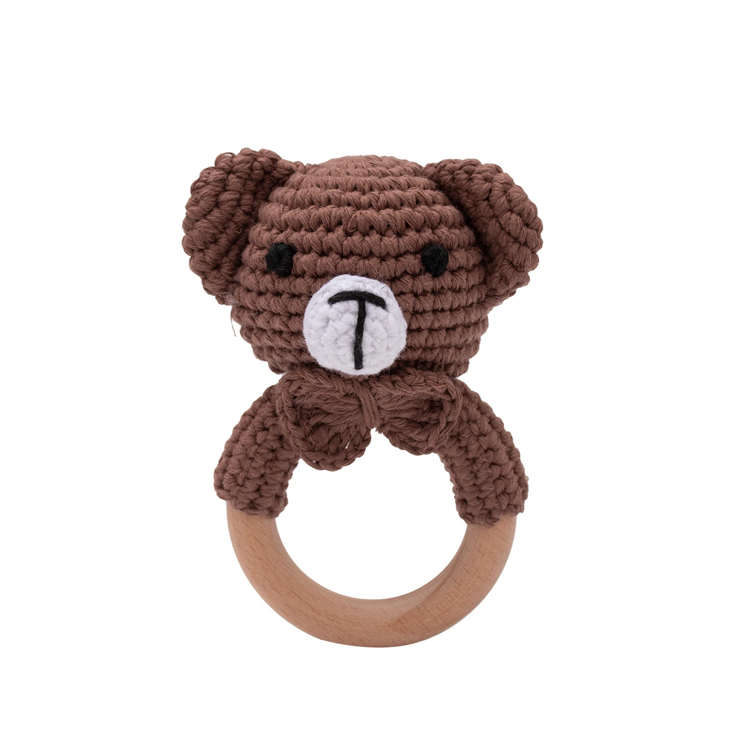 Brown crocheted teddy bear rattle with a matching bow and wooden ring