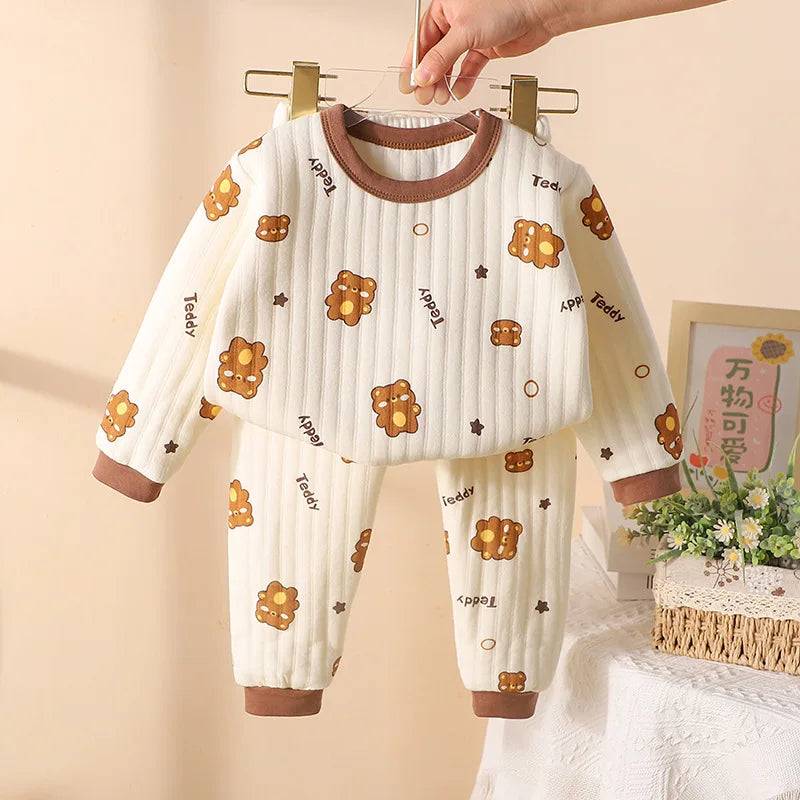 Brown-trimmed pajama set with a cream printed long-sleeve top and matching cuffed pants.