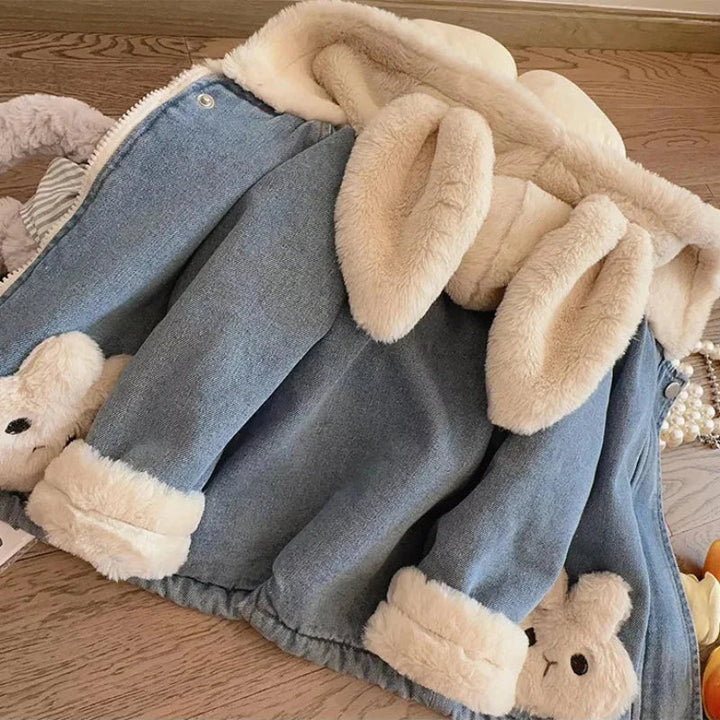 Back view of the blue denim jacket with long plush bunny ears and cream cuffs