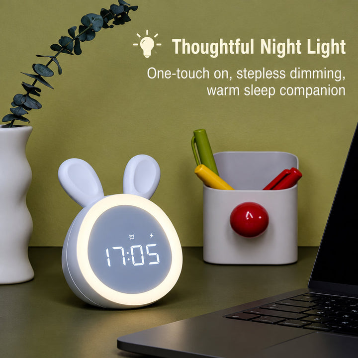 White bunny night-light clock beside a pencil cup and laptop