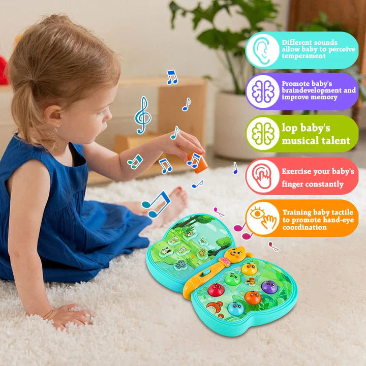Seated child reaching toward the colored buttons on a butterfly learning toy.
