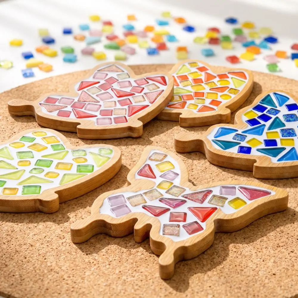 Butterfly mosaic coasters in several color combinations with loose acrylic tiles nearby