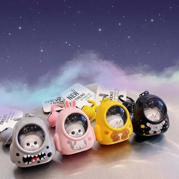 Gray, pink, yellow, and black capsule-style astronaut charms on a tabletop
