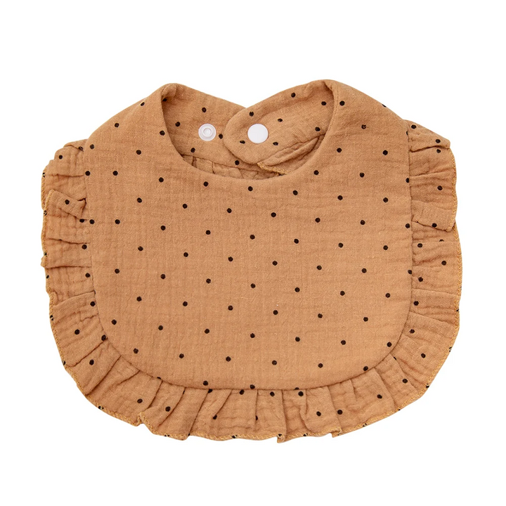 Caramel-colored cotton baby bib with small dark dots and ruffled edging
