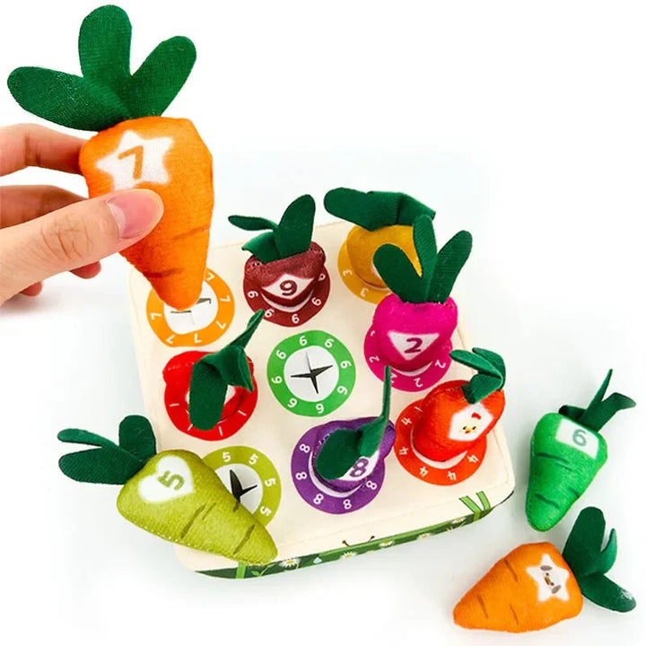 Numbered plush carrots with green tops beside a color-matching garden board