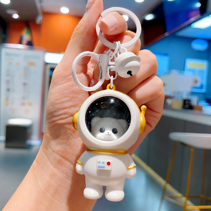 Cat astronaut charm in a white suit with gold-tone helmet details and a key ring