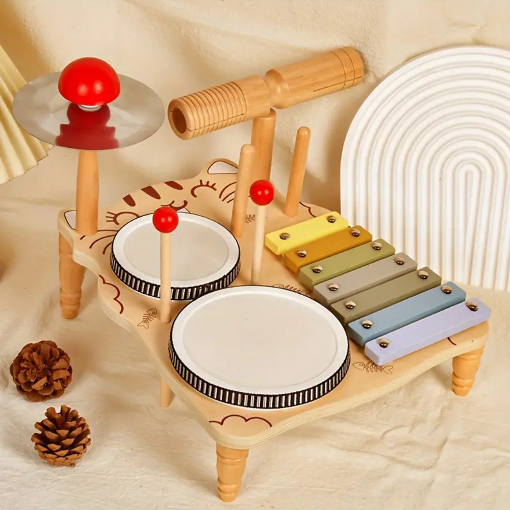 Cat-shaped wooden drum set with two drums, a pastel xylophone, a cymbal, and a wooden rhythm block