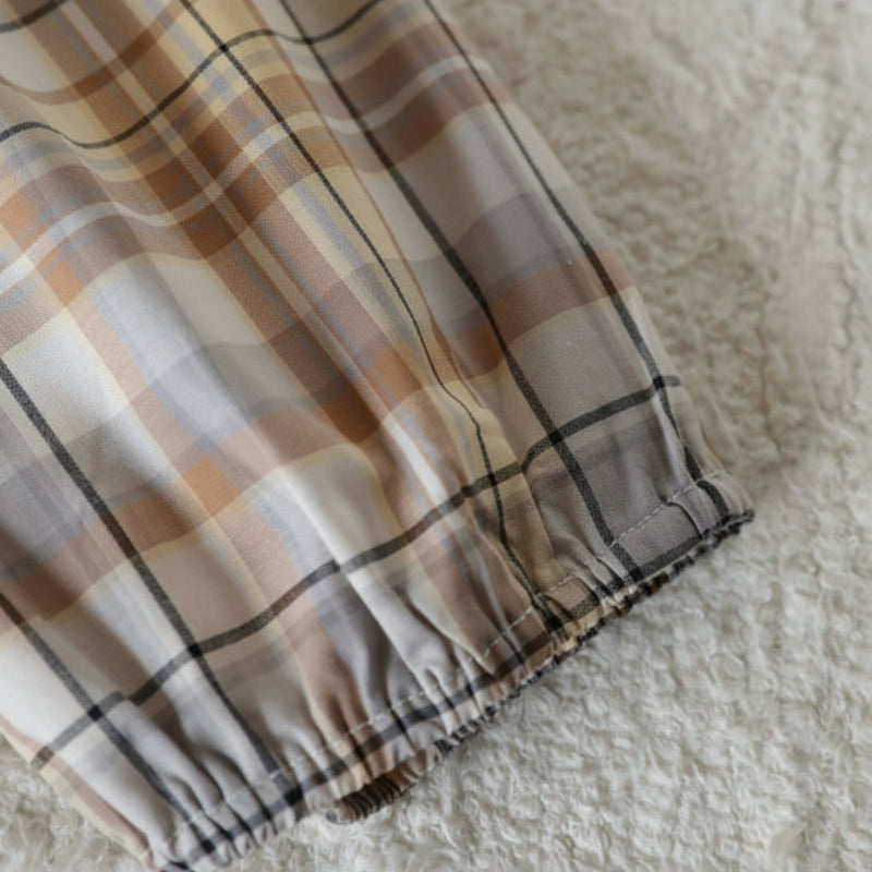 Gathered elastic ankle cuff on beige and brown checkered cotton pants.