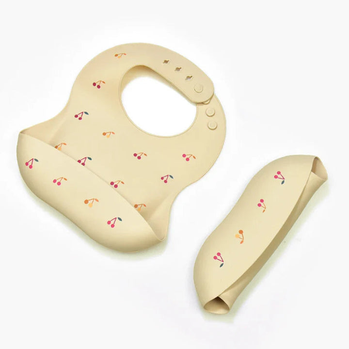 Cherry-print silicone bib shown open and rolled