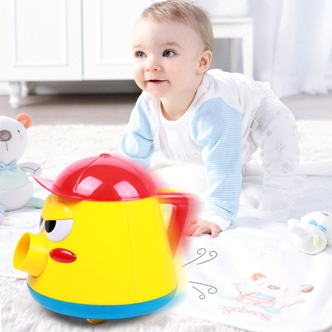 Child on a play mat beside a yellow ball launcher with a red cap