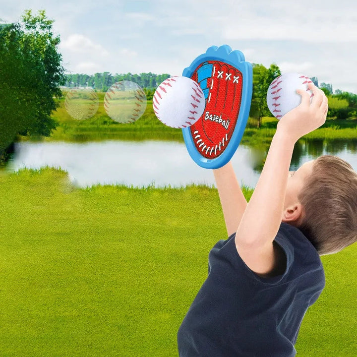 Child raising a blue catch paddle toward a white ball on a grassy lawn