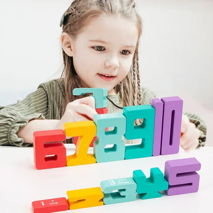 A child arranging brightly colored wooden number blocks on a table.