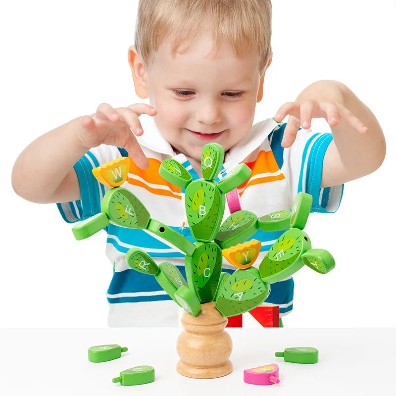 Child adding a letter piece to the wooden cactus, with loose pieces on the table.