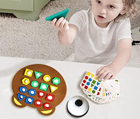 Child holding a green shape beside a bear puzzle board, pattern cards, and a tabletop bell