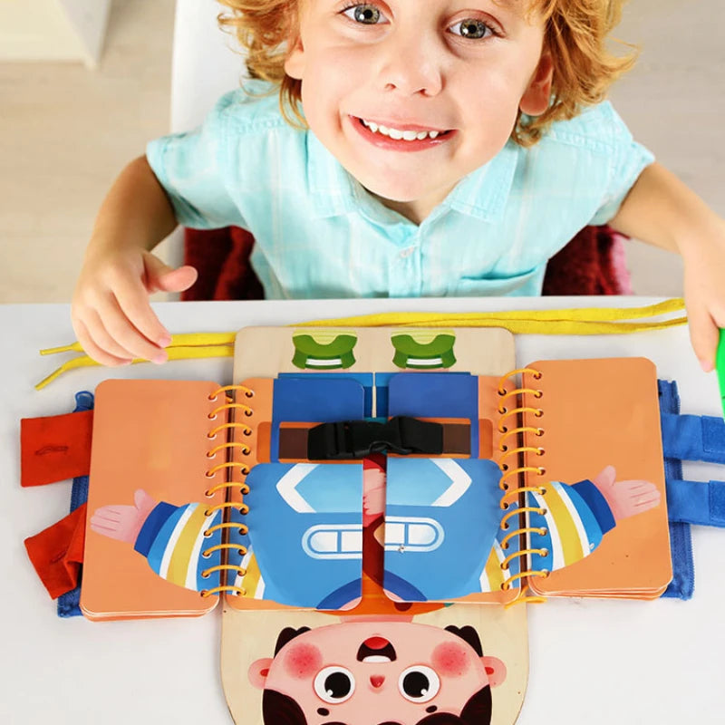 Child exploring an open dress-up activity book with a black buckle and colorful clothing pages