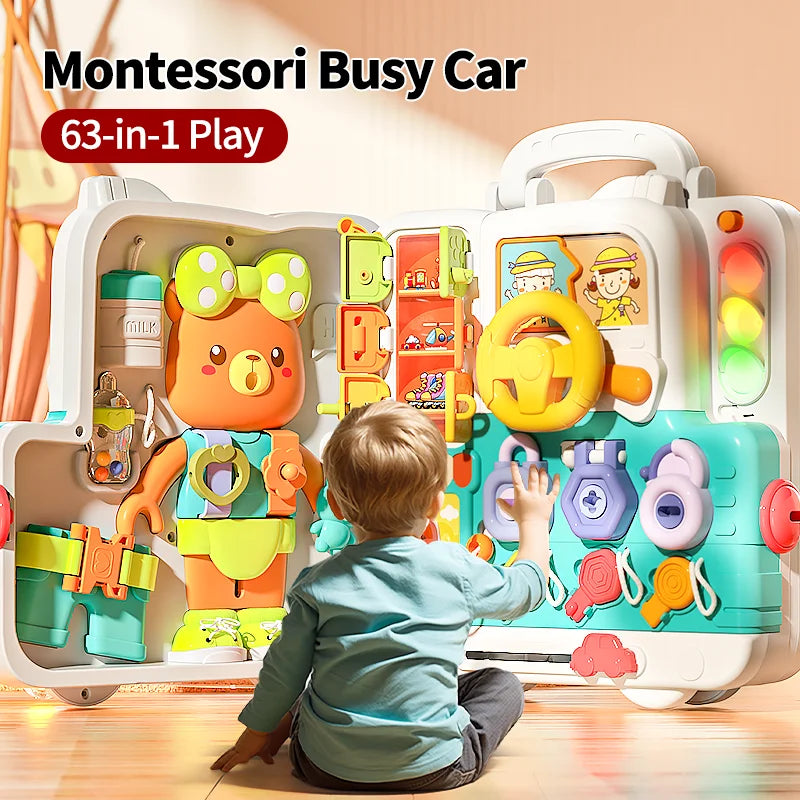 Child sitting in front of an open activity suitcase with a bear panel and steering wheel