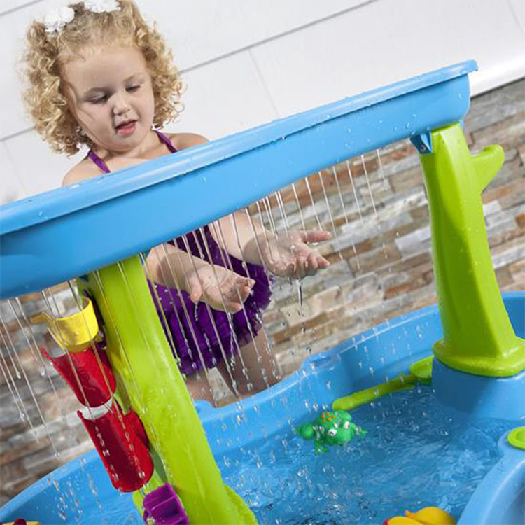 Child reaching into the falling streams from the water table&