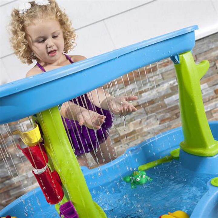 Child reaching into the falling streams from the water table&