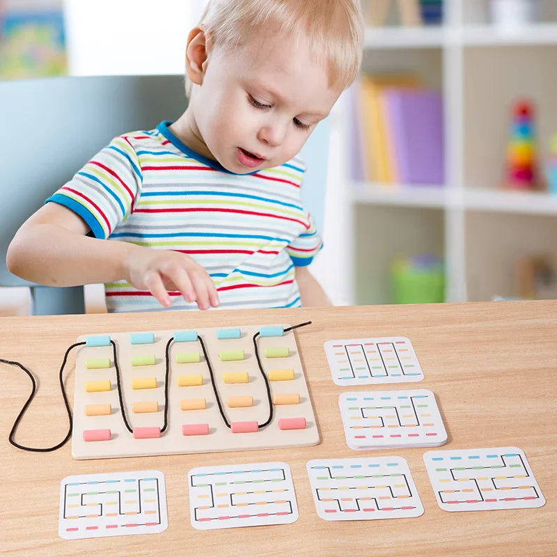 Child exploring a wooden string pattern board with reference cards arranged on the table.