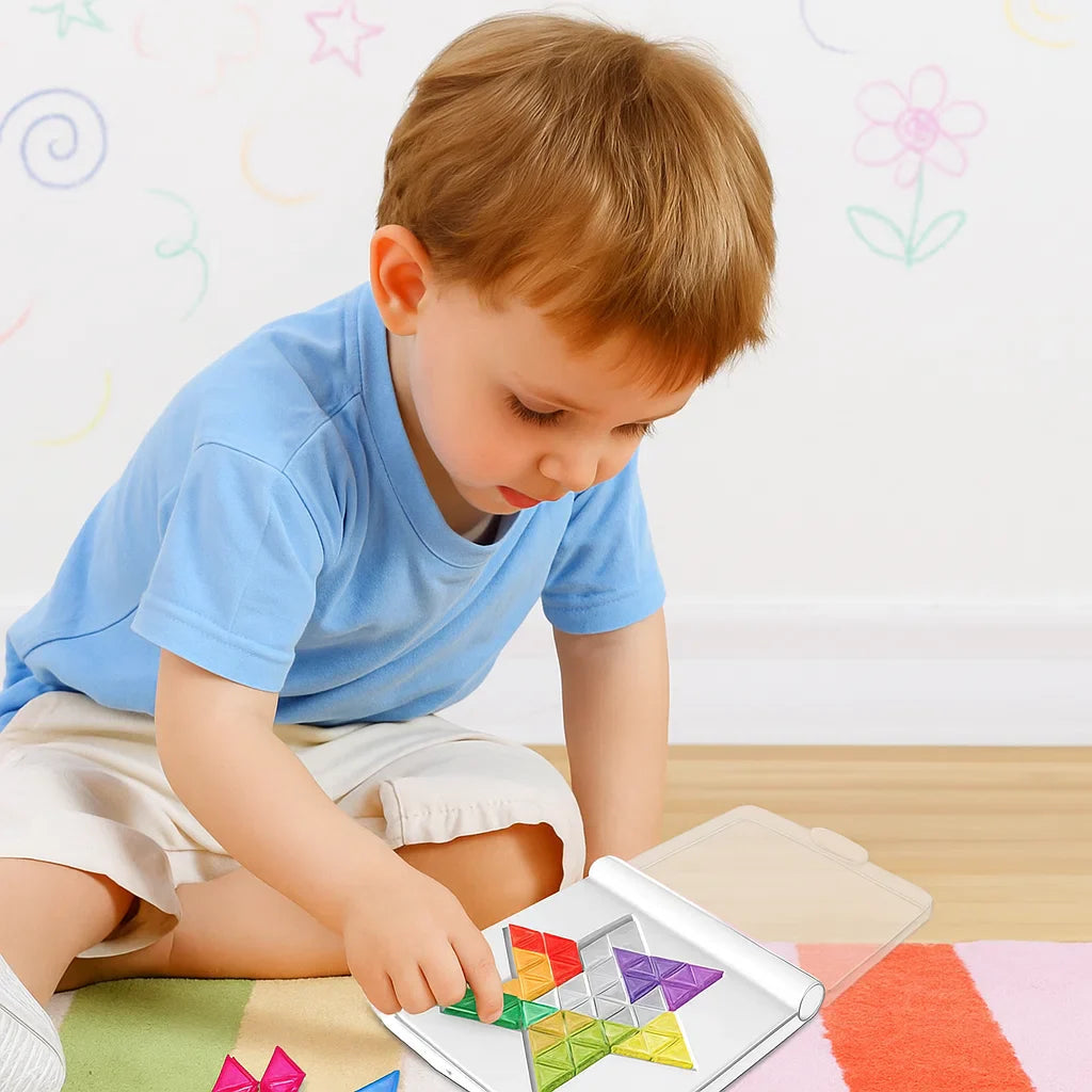 Child fitting colorful geometric pieces into a white puzzle board on the floor